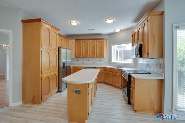 1102 Chesterfield Dr SE, Huntsville, AL 35803 - kitchen featuring stainless steel appliances, backsplash, a kitchen island, plenty of natural light, and a textured ceiling