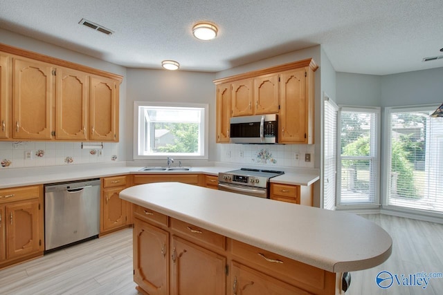 1102 Chesterfield Dr SE, Huntsville, AL 35803 - kitchen featuring stainless steel appliances, a sink, decorative backsplash, light wood finished floors, and light countertops