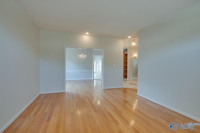 1102 Chesterfield Dr SE, Huntsville, AL 35803 - spare room with a chandelier, light wood finished floors, baseboards, a textured ceiling, and recessed lighting