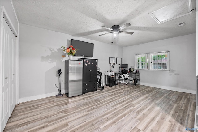 office featuring visible vents, wood finished floors, baseboards, ceiling fan, and a textured ceiling