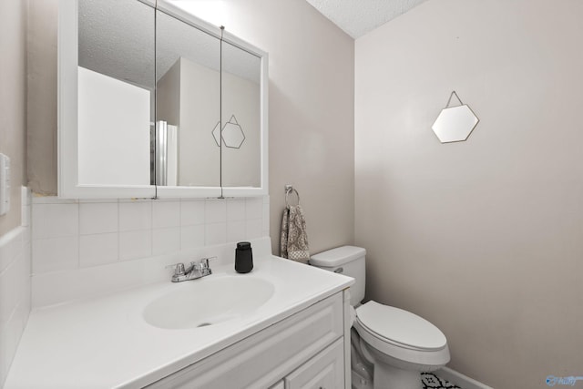 half bath with vanity, decorative backsplash, a textured ceiling, and toilet