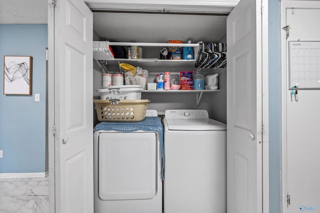 clothes washing area with laundry area, marble finish floor, washing machine and dryer, baseboards, and a textured ceiling