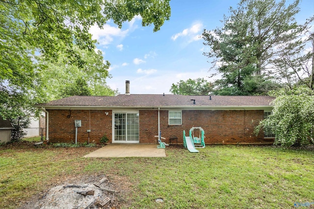 rear view of house featuring fence, a yard, a patio area, and brick siding