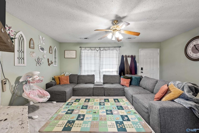 living room with ceiling fan, a textured ceiling, and marble finish floor