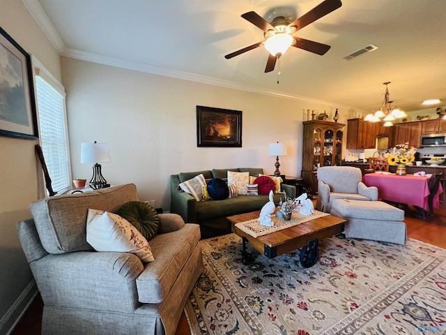 living room featuring hardwood / wood-style flooring, crown molding, and ceiling fan with notable chandelier