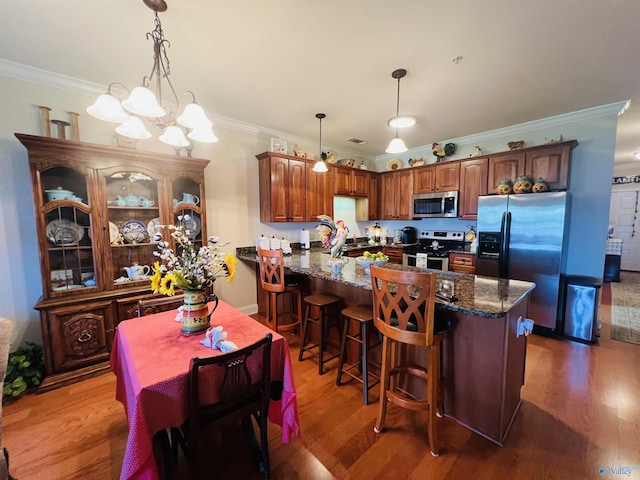 kitchen with crown molding, hardwood / wood-style flooring, and appliances with stainless steel finishes