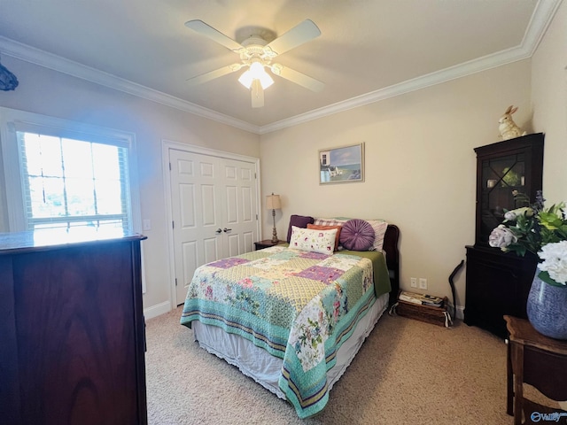 carpeted bedroom featuring ornamental molding, ceiling fan, and a closet