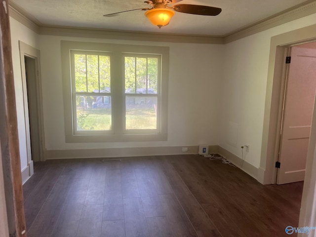 unfurnished room with dark wood-type flooring, ornamental molding, baseboards, and ceiling fan