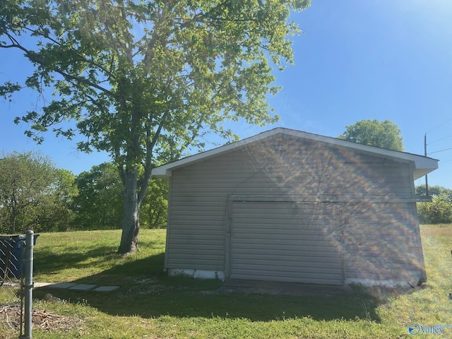 view of home's exterior featuring a lawn and an outdoor structure