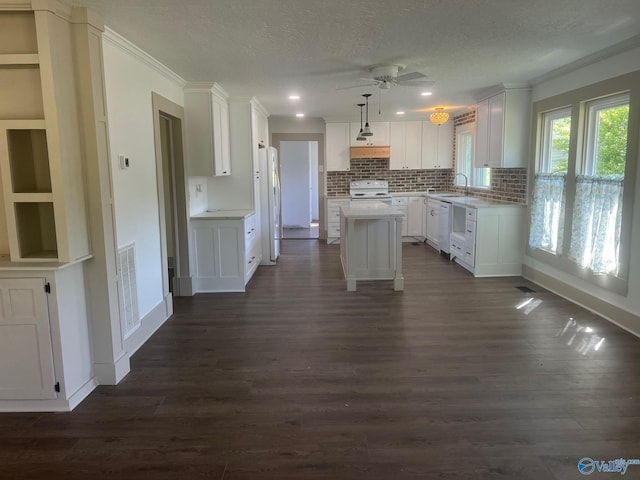 kitchen featuring white cabinets, a textured ceiling, dark wood-style flooring, and white appliances