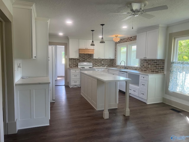 kitchen with a sink, white appliances, white cabinets, under cabinet range hood, and visible vents