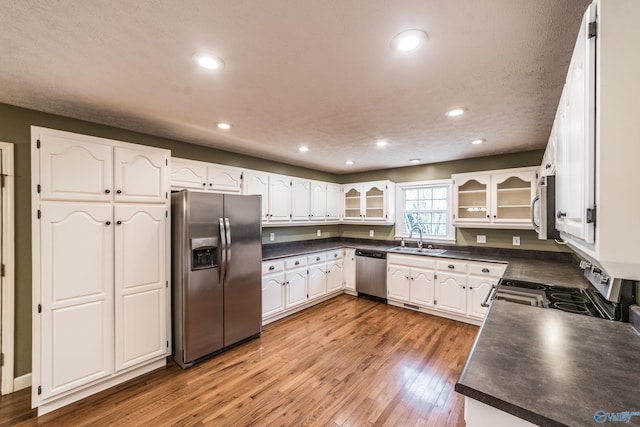 kitchen with sink, hardwood / wood-style floors, white cabinets, and appliances with stainless steel finishes