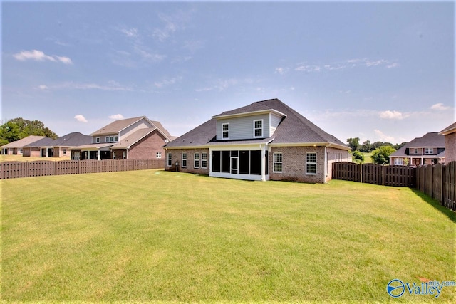 rear view of property featuring a sunroom and a lawn