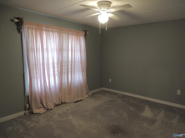 unfurnished room featuring ceiling fan and dark colored carpet