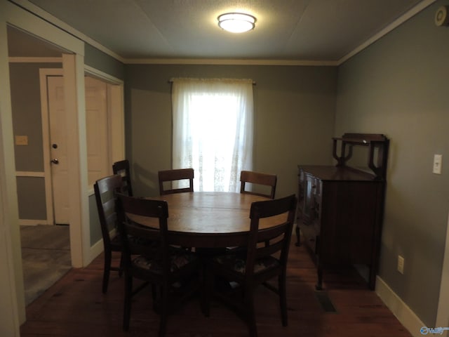 dining room featuring crown molding and dark hardwood / wood-style floors