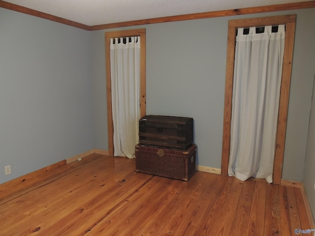 unfurnished bedroom with crown molding and light hardwood / wood-style flooring