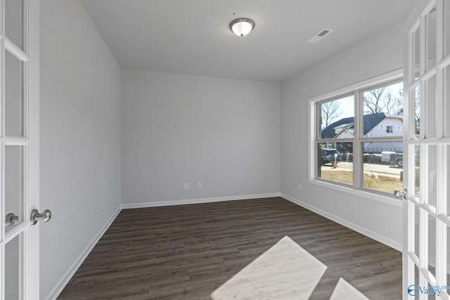 empty room featuring french doors and dark wood-type flooring