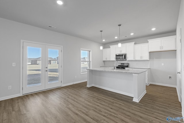 kitchen with sink, decorative light fixtures, a center island with sink, stainless steel appliances, and white cabinets