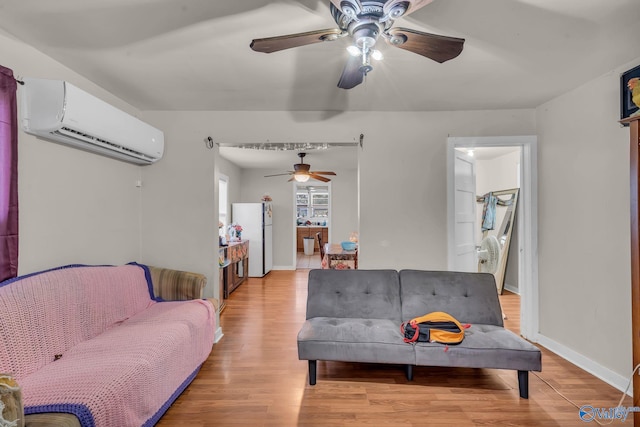 living room featuring ceiling fan, a wall unit AC, and hardwood / wood-style flooring