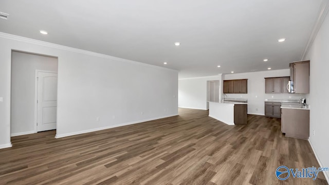 unfurnished living room featuring dark hardwood / wood-style flooring and ornamental molding