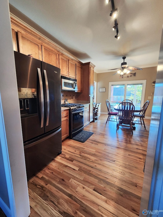 kitchen featuring black appliances, ceiling fan, wood-type flooring, and crown molding