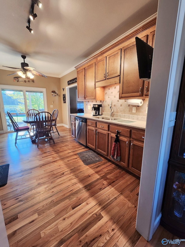 kitchen with light wood-type flooring, tasteful backsplash, ceiling fan, sink, and dishwasher