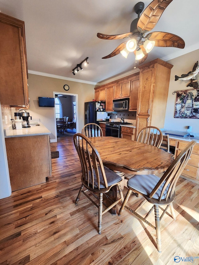 dining room with ceiling fan, wood-type flooring, and ornamental molding