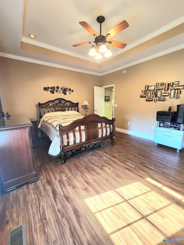 bedroom featuring hardwood / wood-style flooring, ceiling fan, crown molding, and a tray ceiling