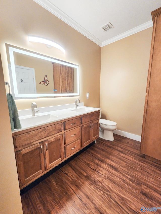 bathroom featuring toilet, vanity, ornamental molding, and hardwood / wood-style flooring