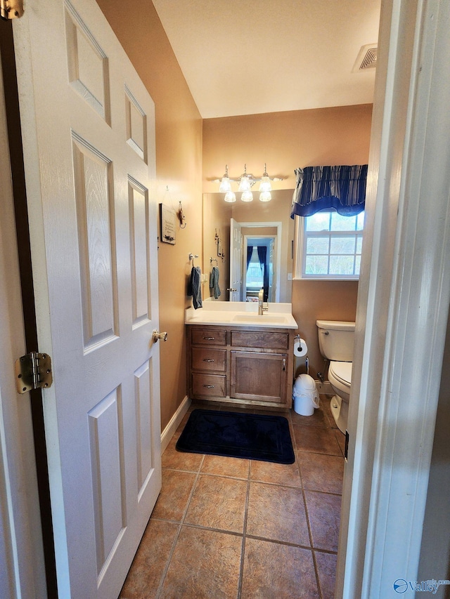 bathroom with tile patterned flooring, vanity, and toilet