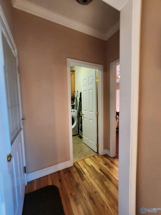 corridor featuring light hardwood / wood-style floors, washer / clothes dryer, and crown molding