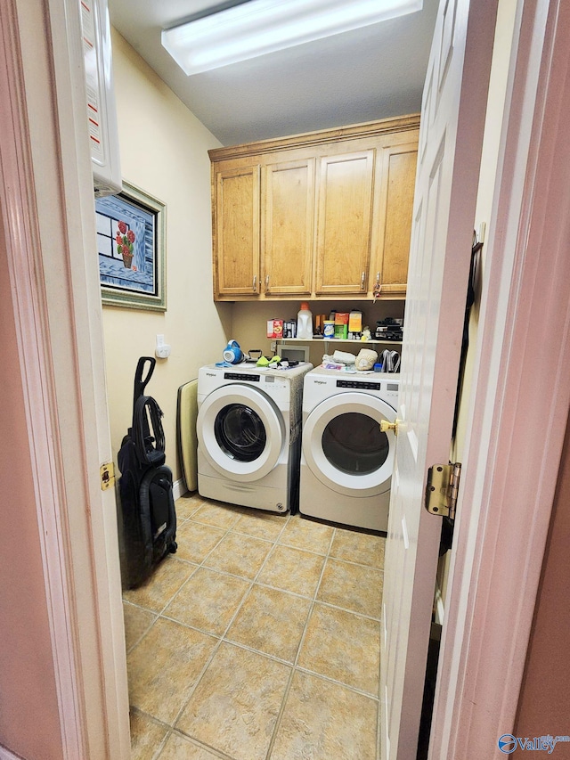 washroom featuring light tile patterned flooring, cabinets, and independent washer and dryer