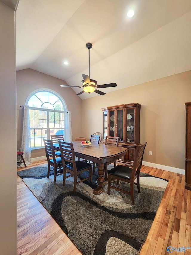 dining area with ceiling fan, vaulted ceiling, and hardwood / wood-style flooring