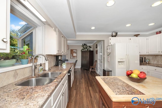 kitchen featuring sink, white cabinetry, appliances with stainless steel finishes, dark hardwood / wood-style floors, and decorative backsplash