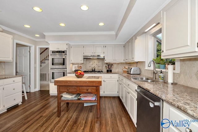 kitchen with appliances with stainless steel finishes, dark hardwood / wood-style flooring, and white cabinetry