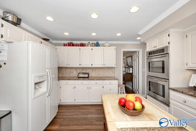 kitchen with white refrigerator with ice dispenser, crown molding, dark hardwood / wood-style floors, white cabinets, and double oven