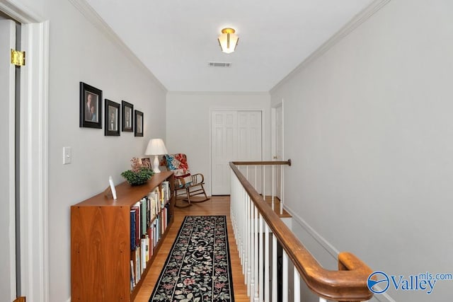 hall with ornamental molding and light hardwood / wood-style flooring