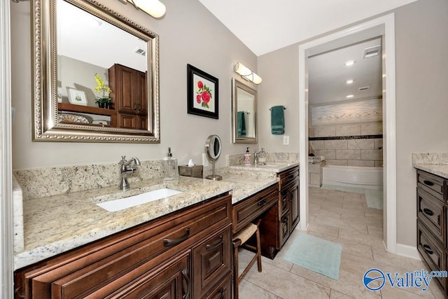 bathroom with vanity, a washtub, and tile patterned floors