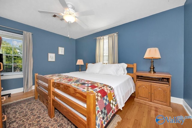 bedroom with multiple windows, ceiling fan, and light hardwood / wood-style flooring