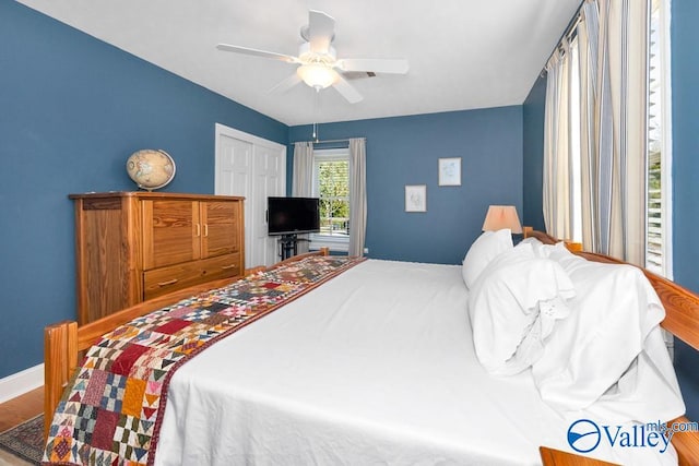 bedroom with a closet, hardwood / wood-style floors, and ceiling fan