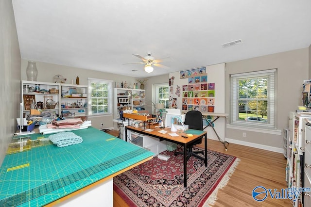 home office featuring ceiling fan, plenty of natural light, and hardwood / wood-style floors