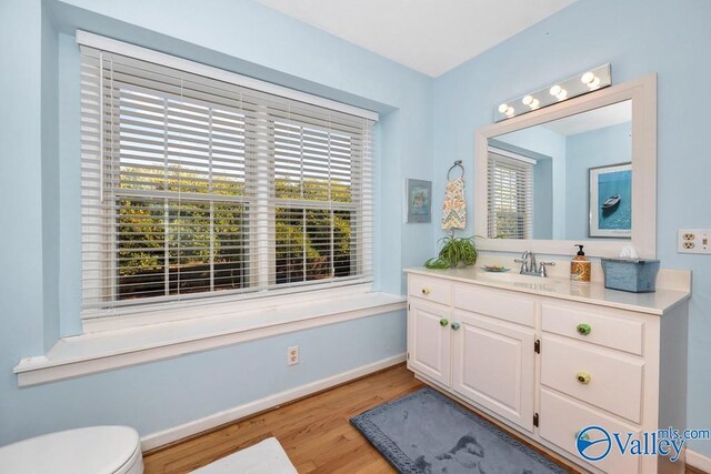 3318 Ohara Rd SW, Huntsville, AL 35801 - half bath with toilet, vanity, wood finished floors, and baseboards