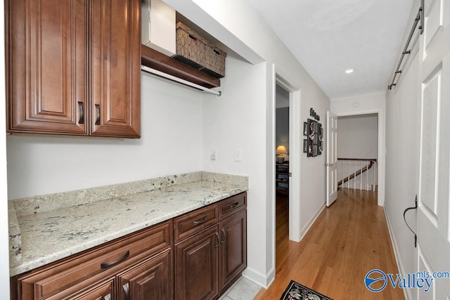 kitchen featuring light wood-type flooring and light stone countertops