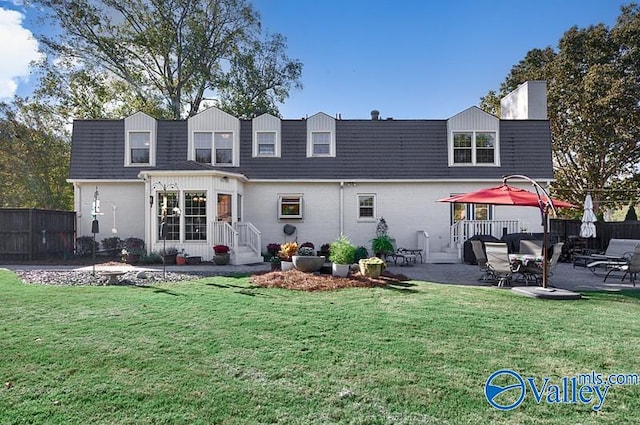 back of house with a yard and a patio