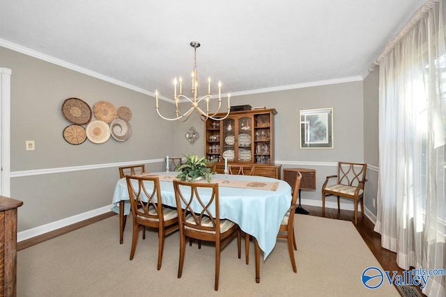 dining room featuring an inviting chandelier, ornamental molding, and hardwood / wood-style flooring