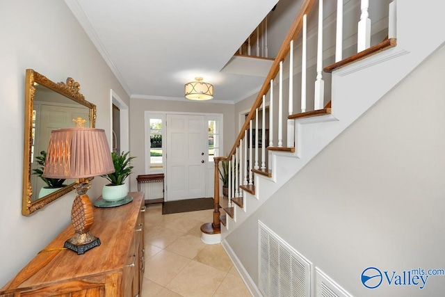 foyer with light tile patterned flooring and crown molding