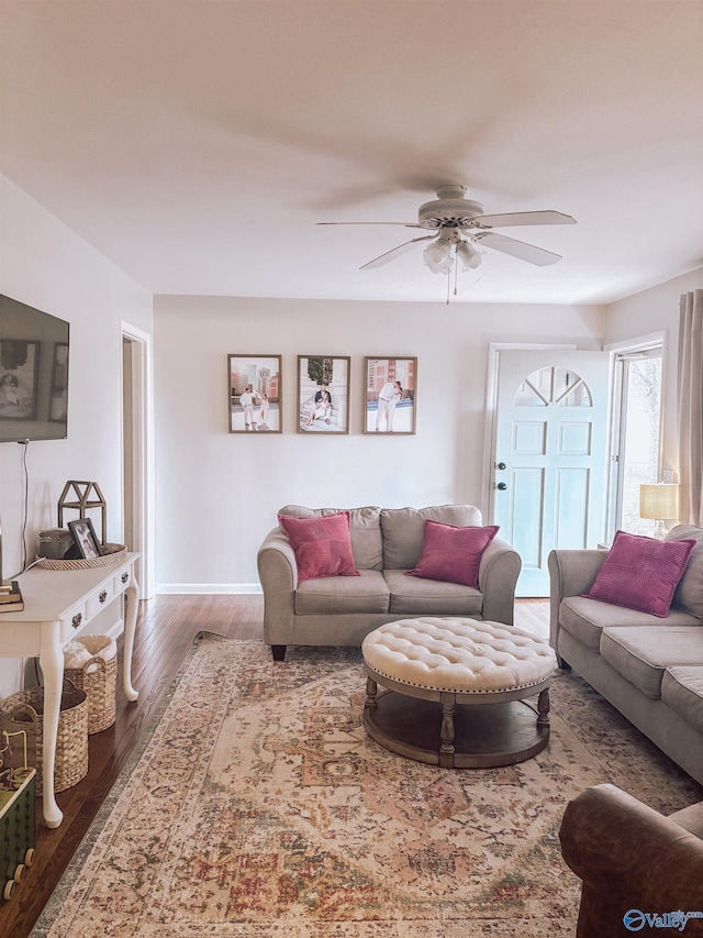 living room with dark wood-type flooring and ceiling fan