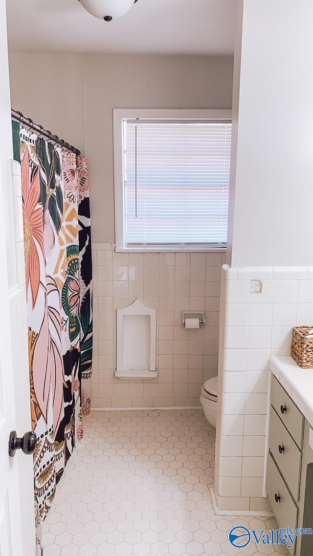 bathroom with tile walls, vanity, a shower with curtain, and toilet