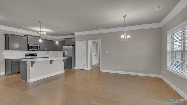 kitchen featuring visible vents, an inviting chandelier, a breakfast bar, light countertops, and appliances with stainless steel finishes