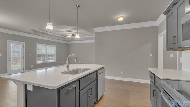 kitchen featuring a sink, crown molding, and gray cabinetry